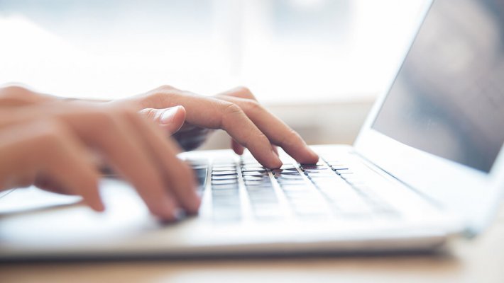 personne qui tape sur un ordinateur portable
